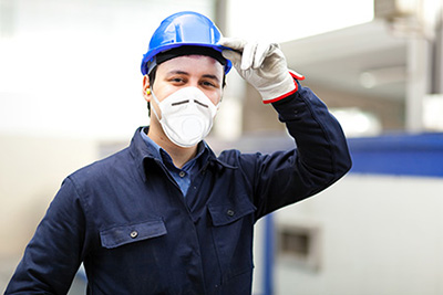 homme en tenue de travail bleue avec casque gant et masque